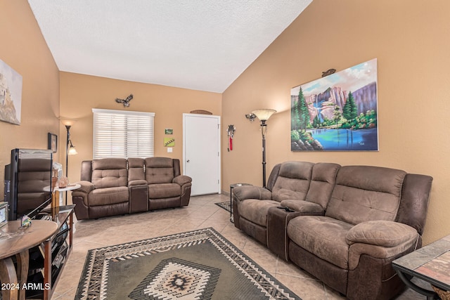 living room featuring a textured ceiling, light tile patterned floors, and vaulted ceiling