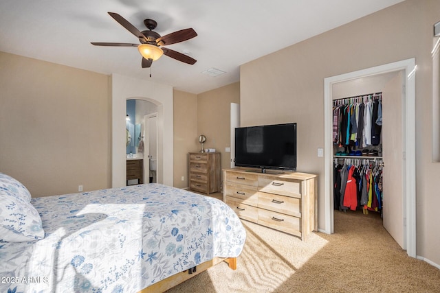 carpeted bedroom featuring a closet, ceiling fan, and ensuite bathroom