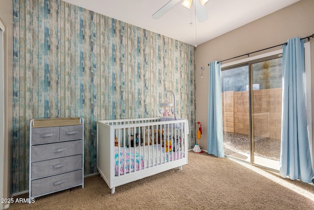 unfurnished bedroom featuring ceiling fan, carpet floors, and a crib