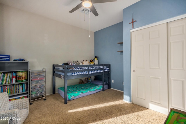 bedroom featuring ceiling fan, a closet, carpet floors, and vaulted ceiling