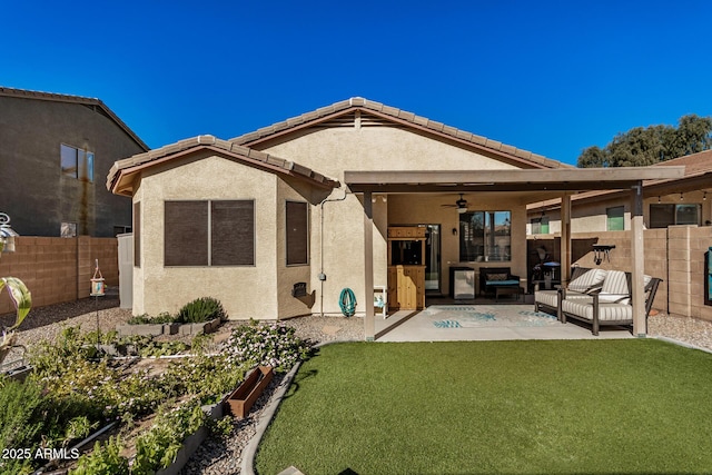 rear view of house featuring ceiling fan, a patio area, an outdoor living space, and a lawn