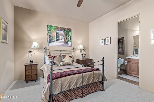 carpeted bedroom featuring ceiling fan and ensuite bathroom