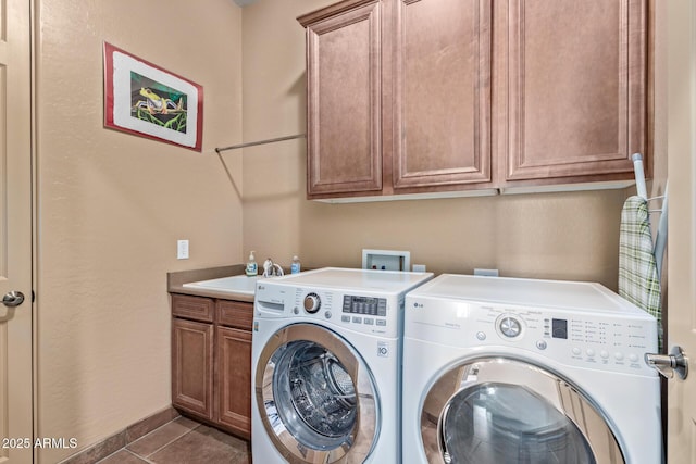 washroom featuring cabinets, washer and clothes dryer, sink, and dark tile patterned flooring