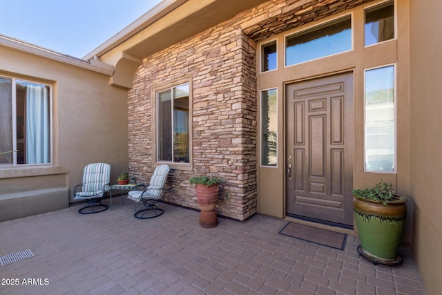 view of exterior entry featuring a patio