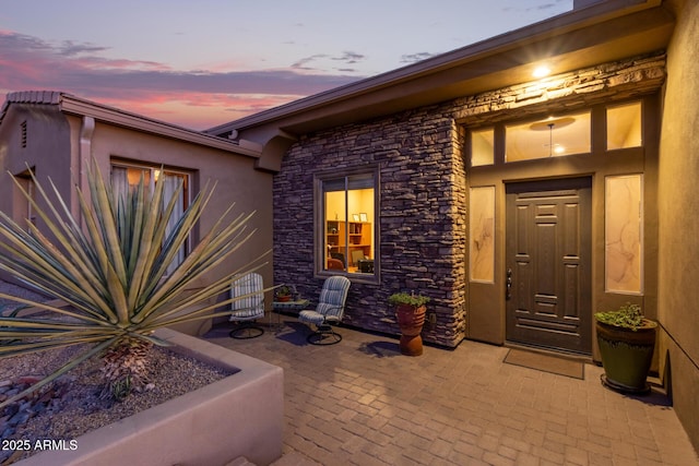 exterior entry at dusk with a patio area