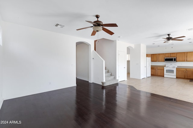 unfurnished living room featuring light wood-type flooring and ceiling fan