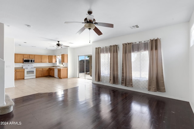 unfurnished living room with light hardwood / wood-style flooring, sink, and ceiling fan