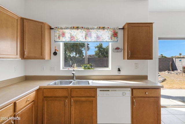 kitchen featuring light tile patterned flooring, white dishwasher, and sink