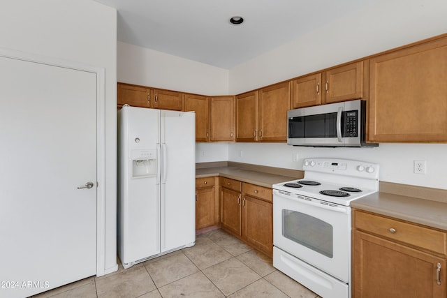 kitchen featuring white appliances and light tile patterned flooring