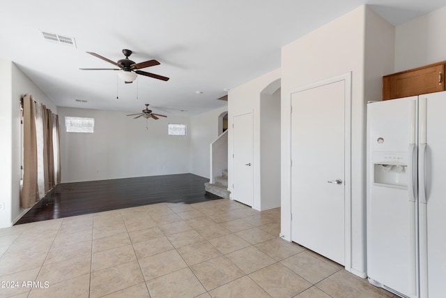 spare room with light wood-type flooring, a healthy amount of sunlight, and ceiling fan