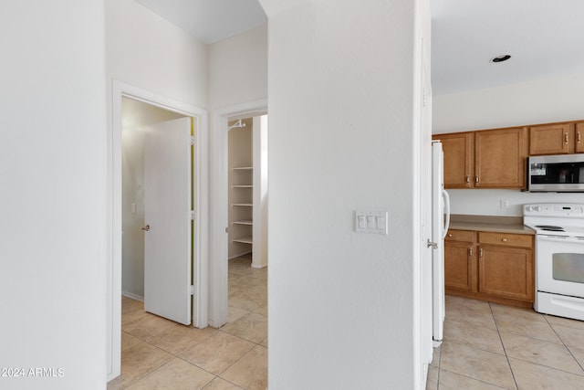 kitchen featuring white appliances and light tile patterned flooring