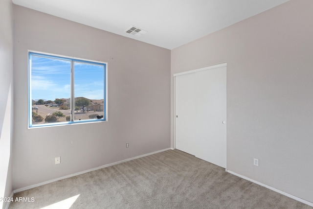 unfurnished room featuring light carpet