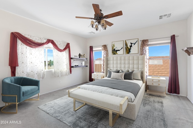 carpeted bedroom with ceiling fan and multiple windows