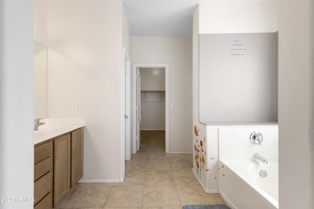 bathroom with tile patterned flooring, vanity, and a tub