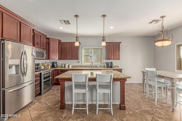 kitchen featuring a sink, stainless steel appliances, a kitchen island, and visible vents