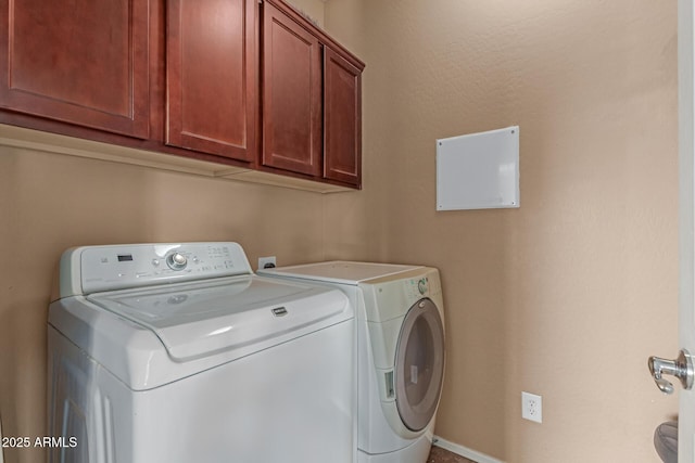 washroom featuring cabinet space and separate washer and dryer