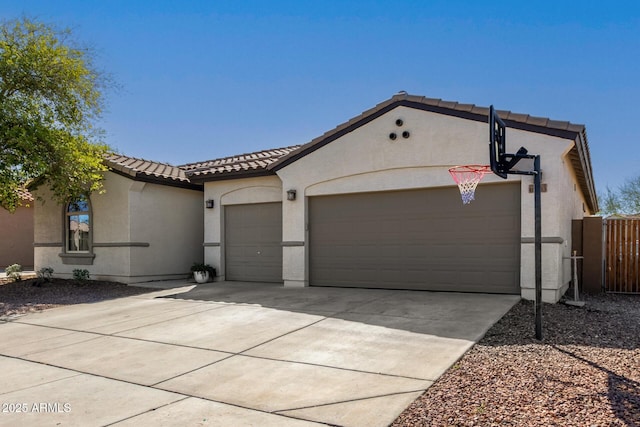 mediterranean / spanish-style house featuring fence, driveway, stucco siding, a garage, and a tile roof