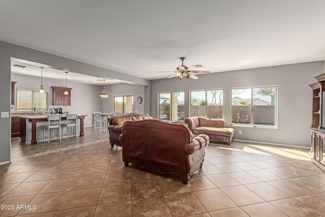 living area with a wealth of natural light, visible vents, and tile patterned flooring