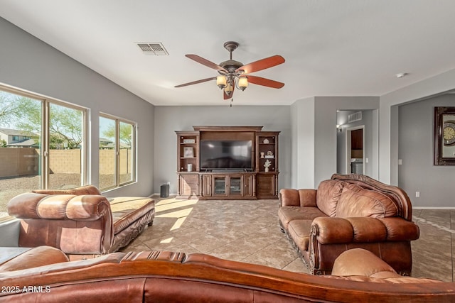 tiled living room featuring visible vents, baseboards, and a ceiling fan