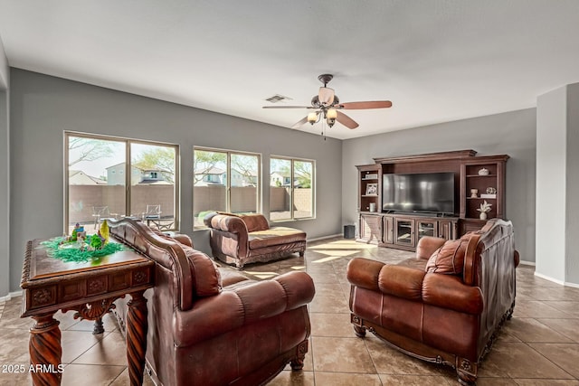 tiled living area with baseboards, visible vents, and ceiling fan