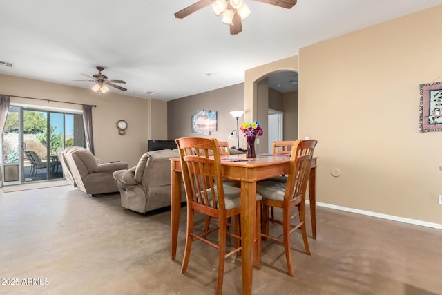 dining area with baseboards, arched walkways, visible vents, ceiling fan, and concrete floors