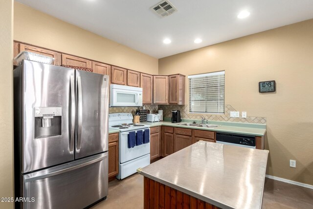 kitchen featuring light countertops, white appliances, a sink, and tasteful backsplash