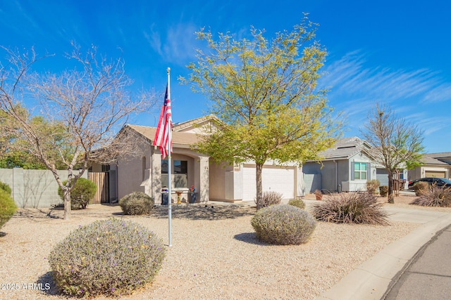 ranch-style home featuring an attached garage, a tile roof, fence, and stucco siding