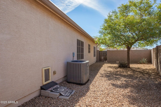 view of property exterior featuring central AC, a fenced backyard, and stucco siding