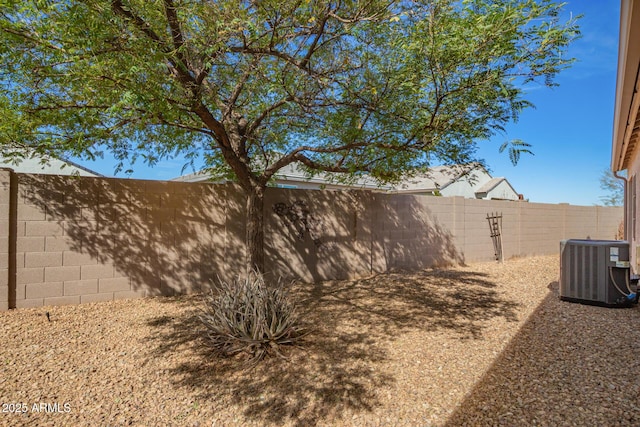 view of yard with a fenced backyard and central AC unit