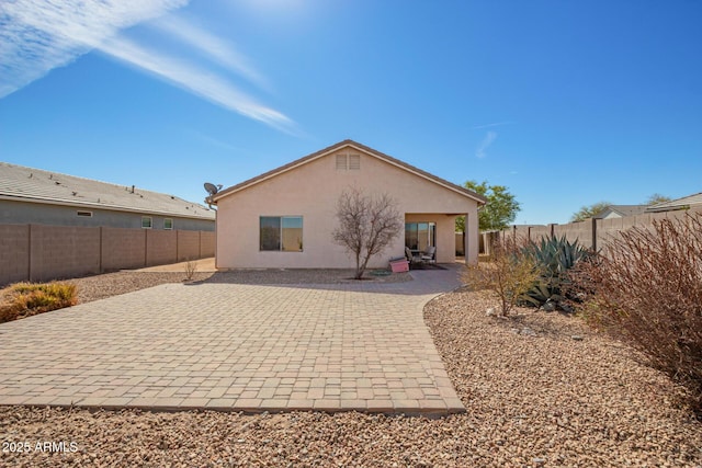 back of house featuring a patio area, a fenced backyard, and stucco siding