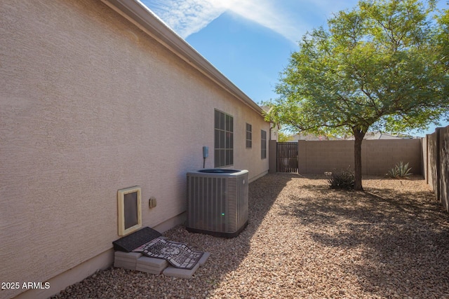 view of property exterior with cooling unit, a fenced backyard, and stucco siding