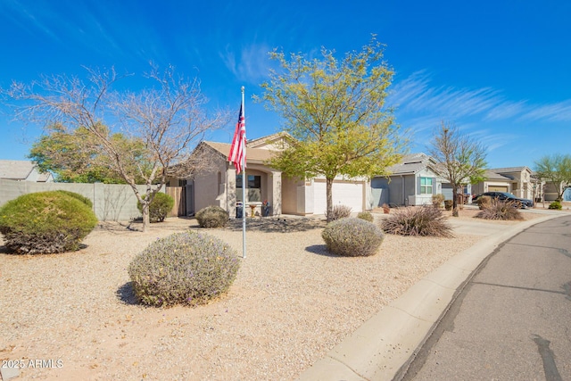 view of front of home featuring an attached garage, fence, and stucco siding