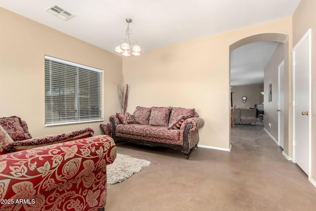 living area with arched walkways, a notable chandelier, visible vents, concrete flooring, and baseboards