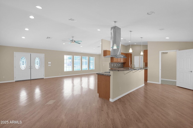 4112 N 4th Ave, Phoenix, AZ 85013 - kitchen with island range hood, brown cabinetry, open floor plan, a kitchen breakfast bar, and ceiling fan