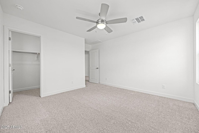 unfurnished bedroom with baseboards, visible vents, light colored carpet, ceiling fan, and a closet