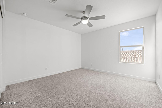 empty room with carpet floors, visible vents, baseboards, and a ceiling fan