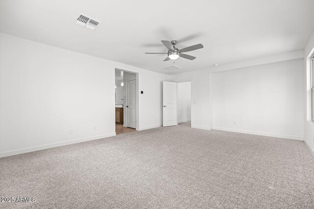 unfurnished bedroom with ensuite bath, baseboards, visible vents, and light colored carpet