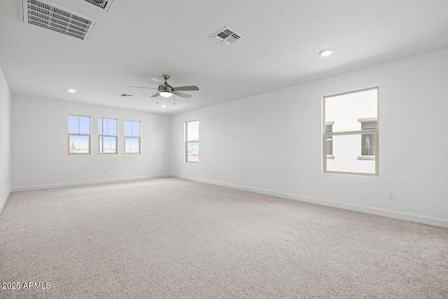 unfurnished room with baseboards, carpet, visible vents, and a ceiling fan