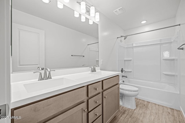 full bath with shower / washtub combination, visible vents, a sink, and wood finished floors