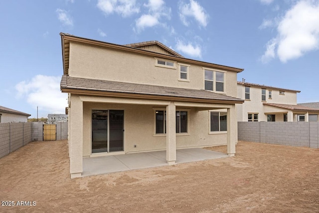 back of property with stucco siding, a fenced backyard, a tiled roof, and a patio