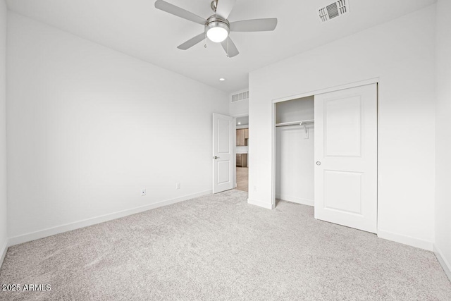 unfurnished bedroom featuring a closet, light carpet, visible vents, and baseboards