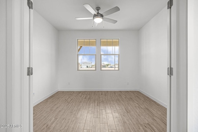 empty room featuring light wood-style flooring, baseboards, and ceiling fan