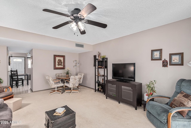 living room featuring a textured ceiling, light colored carpet, and ceiling fan