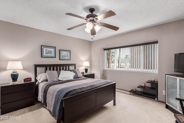 bedroom featuring ceiling fan, light colored carpet, and a textured ceiling