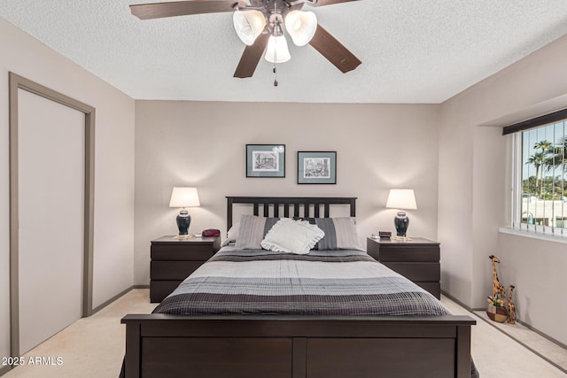 carpeted bedroom with a textured ceiling and ceiling fan