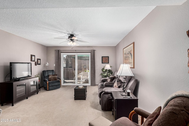 living room featuring a textured ceiling, light colored carpet, and ceiling fan