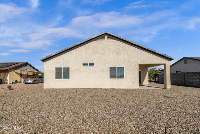 rear view of property with a storage shed and a patio