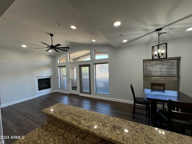 dining space featuring ceiling fan with notable chandelier, lofted ceiling, and dark hardwood / wood-style floors