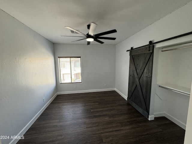 14000 N 94th St Unit 1037, Scottsdale, AZ 85260 - unfurnished bedroom featuring visible vents, ceiling fan, a barn door, baseboards, and dark wood-type flooring