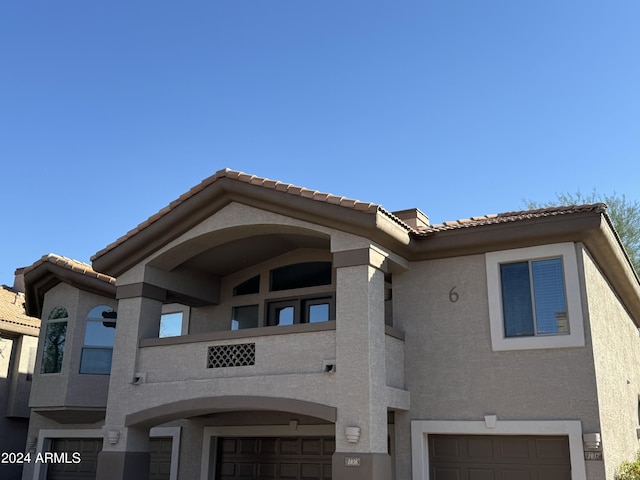 14000 N 94th St Unit 1037, Scottsdale, AZ 85260 - exterior space featuring a balcony, stucco siding, a tiled roof, and an attached garage